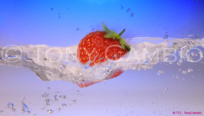 A Strawberry splashing into water, partially submerged